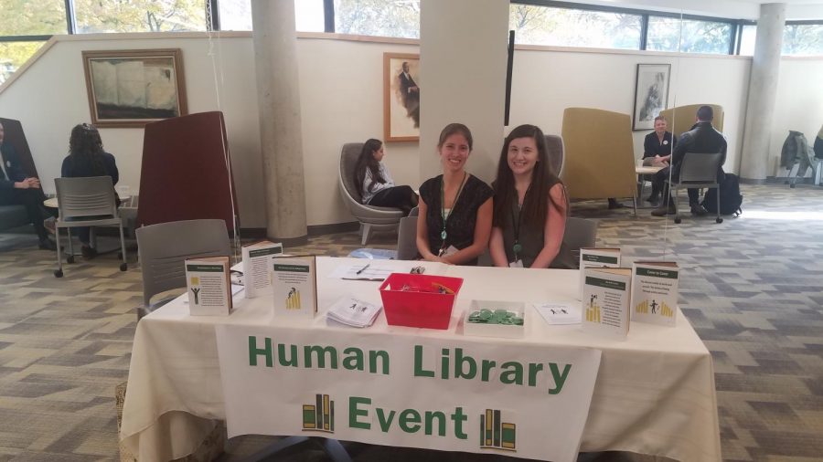 Phoebe DiSalvo-Harms, Humanities Librarian (left), and Emily Adydan, student worker for the library (right), welcome readers as discussions between books and readers happen behind them.